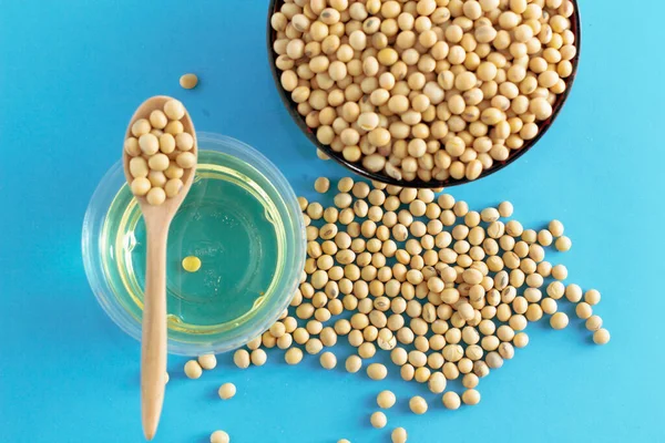 soybean and oil in a bowl on blue background, top view, flat lay, top-down, selective focus.copy space.