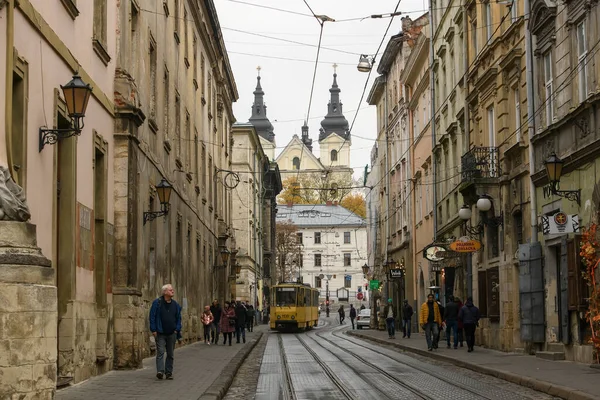 Rynok ou place du marché avec le tram jaune traditionnel et l'église carmélite sur le fond. Lviv, Ukraine. Octobre 2021 — Photo