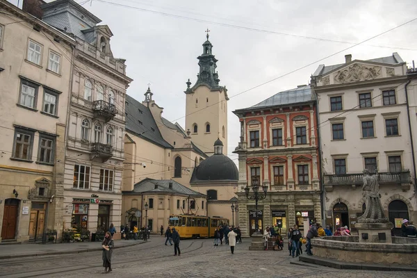 Rynok ou place du marché avec le tram jaune traditionnel et la tour de la cathédrale latine en arrière-plan à Lviv, Ukraine- — Photo