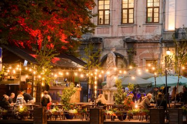 Lviv, Ukrayna 'da restoranları ve kafeleri olan Rynok Meydanı veya Pazar Meydanı' na akşam manzarası. Ekim 2021