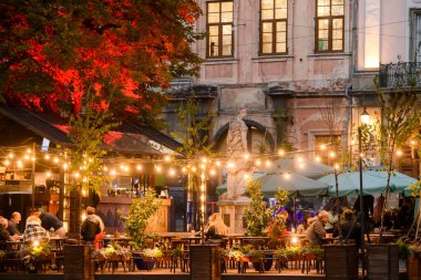 Lviv, Ukrayna 'da restoranları ve kafeleri olan Rynok Meydanı veya Pazar Meydanı' na akşam manzarası. Ekim 2021