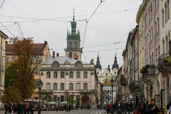 Rynok vagy Market Square harangtorony a Nagyboldogasszony templom és a karmelita templom a háttérben Lviv, Ukrajna. — Stock Fotó