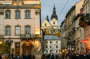 Lviv, Ukrayna 'daki Carmelite Kilisesi' nin arka planında Rynok ya da Market Meydanı 'na akşam manzarası. Ekim 2021