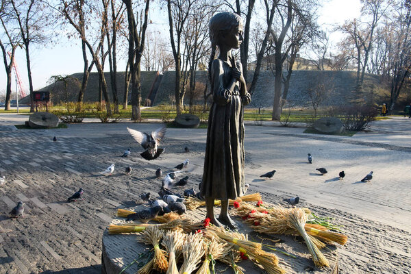 Голуби летают у памятника жертвам Голодомора (большой голод на Украине), которые умерли от голода в 1932-1933 годах. Киев, Украина, октябрь 2021 Черно-белое фото. Высокое качество фото