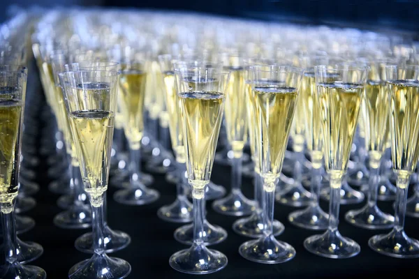 Un sacco di bicchieri con spumante o champagne su sfondo scuro. Festa di festa umore. — Foto Stock