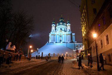 Ukrayna 'nın başkenti Kyiv' deki Andriyivskyy Uzviz Descent Caddesi 'nden St. Andrew Kilisesi' nin akşam karlı manzarası. Aralık 2021