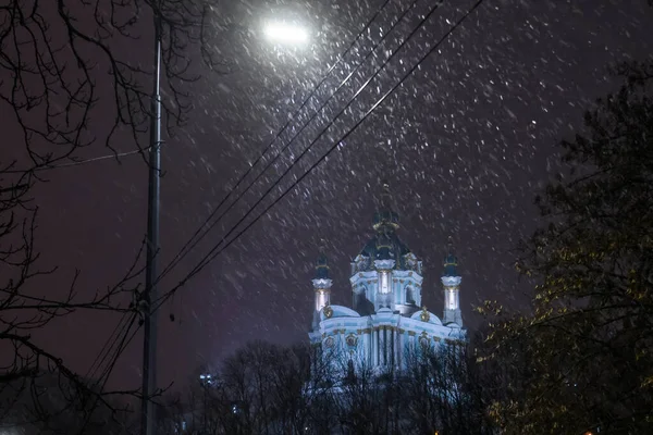 Ukrayna 'nın başkenti Kyiv' deki Andriyivskyy Uzviz Descent Caddesi 'nden St. Andrew Kilisesi' nin akşam karlı manzarası. Aralık 2021