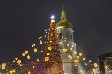 Ukrayna 'nın orta kesimindeki Sofiyska meydanındaki Noel ağacının parlak aydınlatmalı görüntüsü ve Aziz Sophia çan kulesi. Aralık 2021. Yüksek kalite fotoğraf