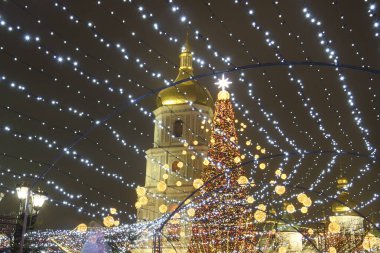 Ukrayna 'nın orta kesimindeki Sofiyska meydanındaki Noel ağacının parlak aydınlatmalı görüntüsü ve Aziz Sophia çan kulesi. Aralık 2021. Yüksek kalite fotoğraf