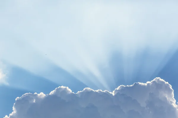 Un cielo azul lleno de nubes y rayos de sol — Foto de Stock