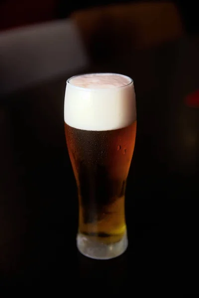 Fresh cold beer, glass of beer on a table in a bar on blurred bokeh background — Stock Photo, Image