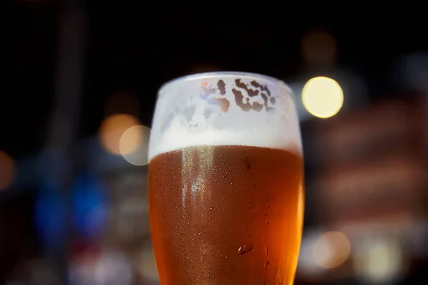 背景のぼけボケ味のバーのテーブルの上のビールのグラス — ストック写真