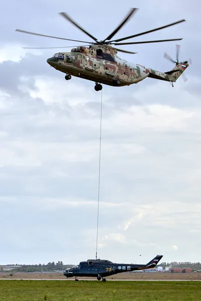 Transporthelikopter Mi-26 T2B transporteert de romp van een gevechtshelikopter op de externe vering. Zware helikopter. Over de codificatie van de NAVO: Halo. 28.09.2021, regio Rostov, Rusland — Stockfoto