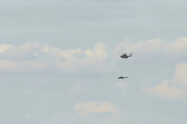 Elicottero da trasporto Mi-26 T2B trasporta la fusoliera di un elicottero da combattimento sulla sospensione esterna. Elicottero pesante. Sulla codificazione della NATO: Halo. 28.09.2021, Regione di Rostov, Russia — Foto Stock