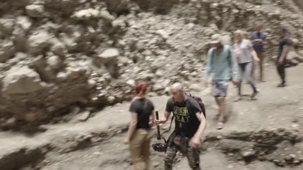 Tourists walking in the gorge, Drone flying through narrow canyon in mountains. Narrow Karadakh gorge. Beauty of untouched nature. Speleology travel. Dlog-M 10 bit. 24.05.2021, Dagestan, Russia — Stock Video