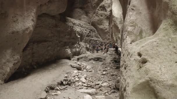 Tourists walking in the gorge, Drone flying through narrow canyon in mountains. Narrow Karadakh gorge. Beauty of untouched nature. Speleology travel. Dlog-M 10 bit. 24.05.2021, Dagestan, Russia — Vídeo de Stock