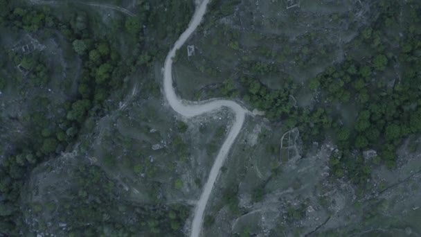 Serpentina incrível nas montanhas. Vista aérea do assentamento nas montanhas, construído em uma estrada sinuosa. Paisagem montanhosa, infra-estrutura em regiões remotas. Dlog-M 10 bits — Vídeo de Stock