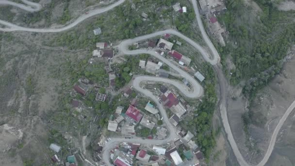 Incredible serpentine in the mountains. Aerial View of settlement in the mountains, built on a winding road. Mountain landscape, infrastructure in remote regions. Dlog-M 10 bit — Stockvideo