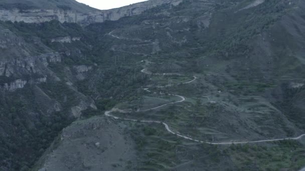 Increíble serpentina en las montañas. Vista aérea del asentamiento en las montañas, construido en un camino sinuoso. Paisaje de montaña, infraestructura en regiones remotas. Dlog-M 10 bit — Vídeo de stock