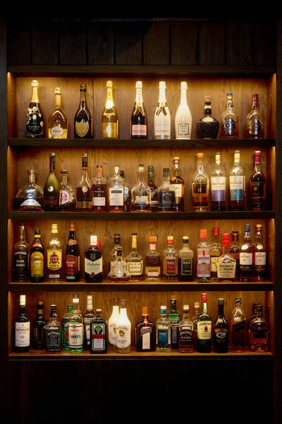 Flessen met alcohol in een bar. Flessen met alcoholische dranken liggen in de schappen. Bar aan de muur. 06.06.2021, regio Rostov, Rusland — Stockfoto