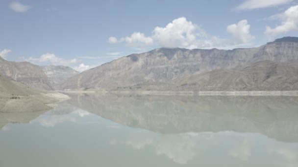 Volando sobre el agua. vista en hermoso lago en las montañas. Hermoso paisaje de montaña y reflejo en aguas tranquilas, increíble costa. Embalse de Irganai, Daguestán. Dlog-M 10 bit — Vídeos de Stock