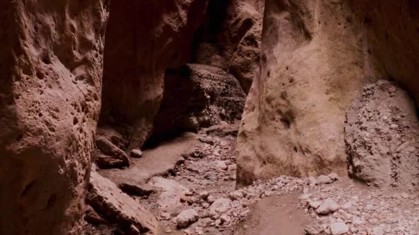 Drone flying through narrow canyon in mountains. Narrow dark gorge created by water. Rift in ground, high ancient cliff walls. Fabulous beauty of untouched nature. Speleology travel. 10 bit Video — Stock videók