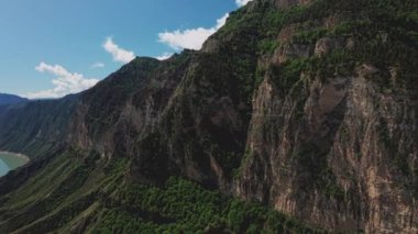 Dağlardaki güzel gölün hava manzarası. Güzel dağ manzarası ve sakin sulardaki yansıma, inanılmaz sahil şeridi ve dağlık arazi. Irganai rezervuarı, Dağıstan. 10 bit Video