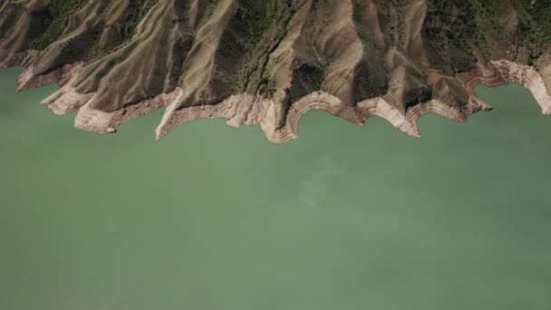 Uitzicht vanuit de lucht in een prachtig meer in de bergen. Prachtig berglandschap en reflectie in rustig water, ongelooflijke kustlijn en bergachtig terrein. Irganai reservoir, Dagestan. 10 bit Video — Stockvideo