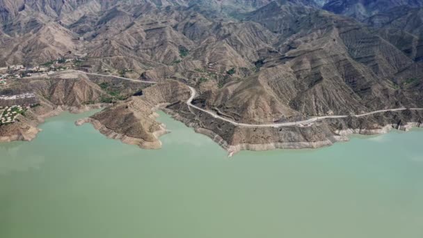 Luftaufnahme in einem schönen See in den Bergen. Schöne Berglandschaft und Spiegelung in ruhigem Wasser, unglaubliche Küste und bergiges Gelände. Irganai-Stausee, Dagestan. 10 bit Video — Stockvideo