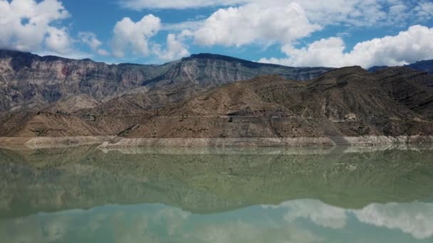 Vliegen over water. uitzicht op het prachtige meer in de bergen. Prachtig berglandschap en reflectie in rustig water, ongelooflijke kustlijn. Irganai reservoir, Dagestan. 10 bit Video — Stockvideo