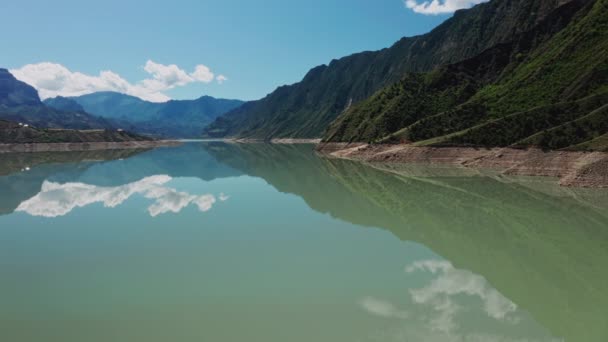 Fliegen über Wasser. Blick in den schönen See in den Bergen. Schöne Berglandschaft und Spiegelung in ruhigem Wasser, unglaubliche Küste. Irganai-Stausee, Dagestan. 10 bit Video — Stockvideo