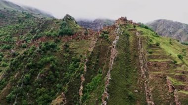 Gamsutl köyü, dağlarda terk edilmiş. Hayalet kasaba, eski bir yerleşim yerinin kalıntıları, Dağıstan dağlarındaki zapt edilemez dağ kalesi. Antik bir köyün havadan görünüşü. 10 bit Video