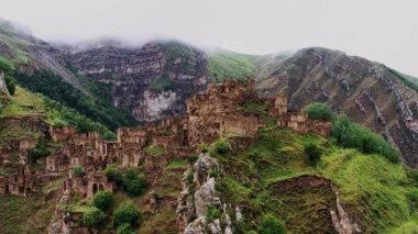 Gamsutl köyü, dağlarda terk edilmiş. Hayalet kasaba, eski bir yerleşim yerinin kalıntıları, Dağıstan dağlarındaki zapt edilemez dağ kalesi. Antik bir köyün havadan görünüşü. 10 bit Video