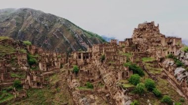 Gamsutl köyü, dağlarda terk edilmiş. Hayalet kasaba, eski bir yerleşim yerinin kalıntıları, Dağıstan dağlarındaki zapt edilemez dağ kalesi. Antik bir köyün havadan görünüşü. 10 bit Video