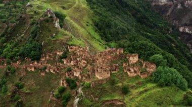 Gamsutl köyü, dağlarda terk edilmiş. Hayalet kasaba, eski bir yerleşim yerinin kalıntıları, Dağıstan dağlarındaki zapt edilemez dağ kalesi. Antik bir köyün havadan görünüşü. 10 bit Video