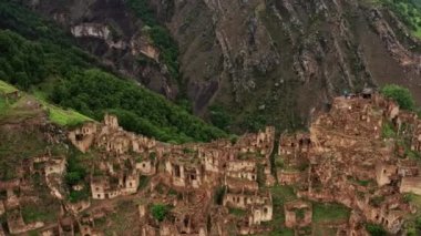 Gamsutl köyü, dağlarda terk edilmiş. Hayalet kasaba, eski bir yerleşim yerinin kalıntıları, Dağıstan dağlarındaki zapt edilemez dağ kalesi. Antik bir köyün havadan görünüşü. 10 bit Video