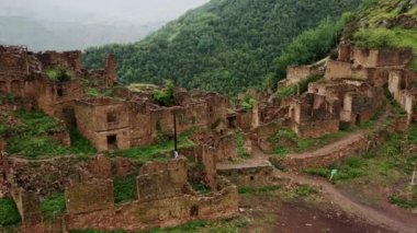 Gamsutl köyü, dağlarda terk edilmiş. Hayalet kasaba, eski bir yerleşim yerinin kalıntıları, Dağıstan dağlarındaki zapt edilemez dağ kalesi. Antik bir köyün havadan görünüşü. 10 bit Video