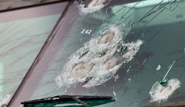 Armored glass after of a direct hit from an automatic weapon. Safety glass after being hit by a bullet. Bulletproof glass armored car after gunshot — Fotografia de Stock