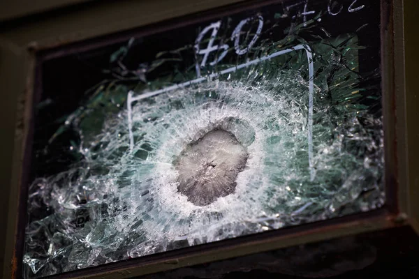 Gepantserd glas na een voltreffer van een automatisch wapen. Veiligheidsglas na geraakt te zijn door een kogel. Kogelvrij glas gepantserde auto na schot — Stockfoto
