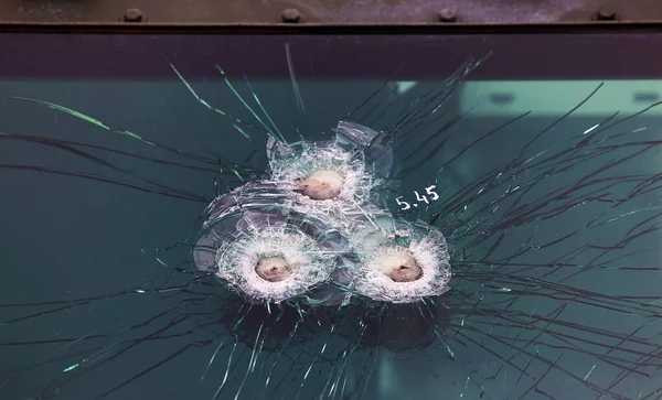 Armored glass after of a direct hit from an automatic weapon. Safety glass after being hit by a bullet. Bulletproof glass armored car after gunshot lizenzfreie Stockbilder