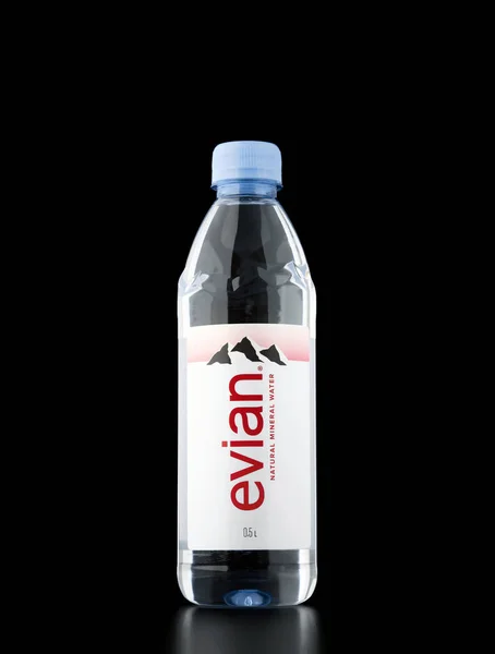 依云天然矿泉水在黑色背景上.Evian是来自Evian les Bains附近多个水源的矿泉水品牌。2021年12月26日，俄罗斯罗斯托夫地区 — 图库照片