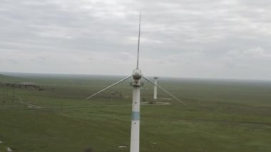 Enerji üretimi için güçlü rüzgar türbini çiftliğinin havadan görüntüsü. Rüzgar güç türbinleri sürdürülebilir gelişim için temiz yenilenebilir enerji üretiyor. Alternatif enerji. 4K