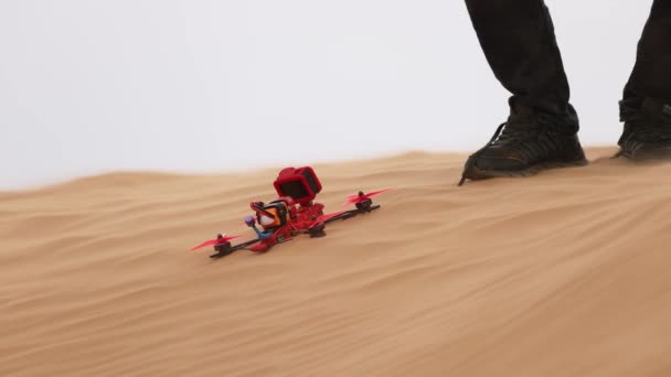 Quadricóptero desportivo na areia no deserto. Aterragem segura no deserto. câmera lenta 120 fps de vídeo — Vídeo de Stock