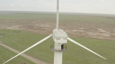 Enerji üretimi için güçlü rüzgar türbini çiftliğinin havadan görüntüsü. Rüzgar güç türbinleri sürdürülebilir gelişim için temiz yenilenebilir enerji üretiyor. Alternatif enerji. 4K, 10 bit, DJI DLog-M profili