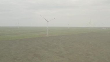 Enerji üretimi için güçlü rüzgar türbini çiftliğinin havadan görüntüsü. Rüzgar güç türbinleri sürdürülebilir gelişim için temiz yenilenebilir enerji üretiyor. Alternatif enerji. 4K, 10 bit, DJI DLog-M profili