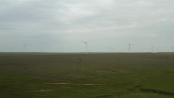 Enerji üretimi için güçlü rüzgar türbini çiftliğinin havadan görüntüsü. Rüzgar güç türbinleri sürdürülebilir gelişim için temiz yenilenebilir enerji üretiyor. Alternatif enerji. 4K — Stok video