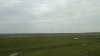 Enerji üretimi için güçlü rüzgar türbini çiftliğinin havadan görüntüsü. Rüzgar güç türbinleri sürdürülebilir gelişim için temiz yenilenebilir enerji üretiyor. Alternatif enerji. 4K