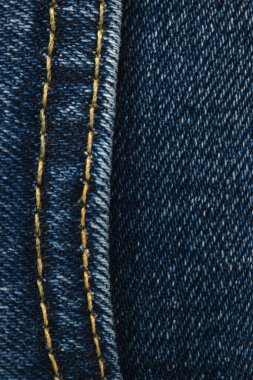 Kotun dikişleri yakın plan. Kot pantolon dikiyorum. Kot pantolonun arka planını kapat. Denim dokusu.
