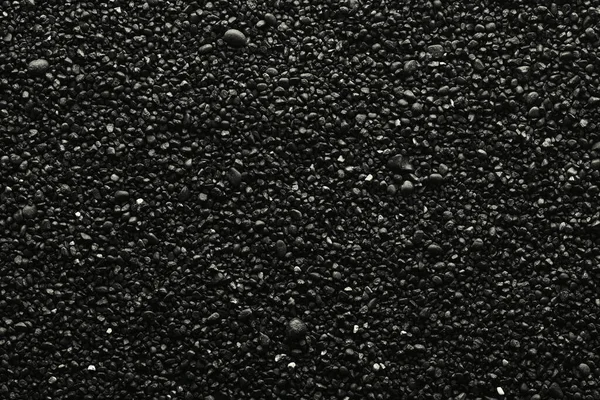 Texture of black volcanic sand for background. Black Sand beach macro photography. Close-up view of volcanic sand surface. Icelandic Black Sand macro photography. Black pebble background — Stock Photo, Image