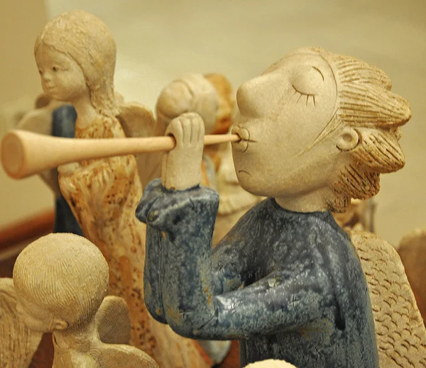 Boy out of clay plays on a pipe — Stock Photo, Image